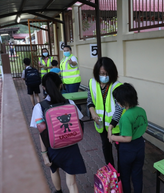 负责防疫工作的爱心家长提供消毒搓手液，让学生们在进入校园之前洗手，保持个人卫生。