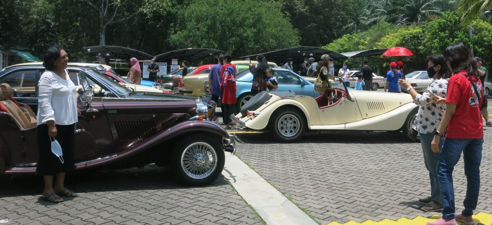 古董车爱好者在参观之余，也不忘与古董车合照。