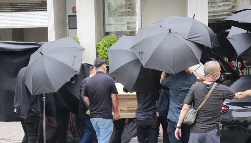 载着陈木胜遗体的西式灵车到场时，数十名穿黑衣工作人员即拉起黑布及撑起雨伞遮挡。