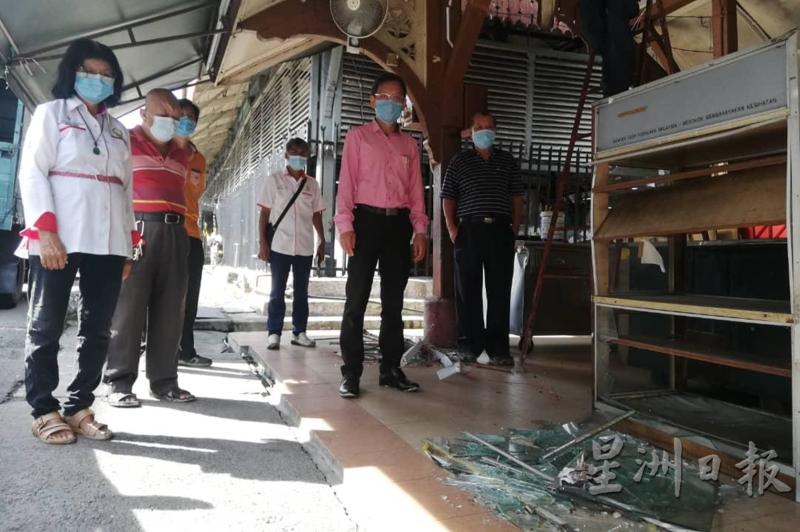 廖泰义（右二）与服务团队视察旧玻璃柜摔破后，留下一地的碎玻璃。
