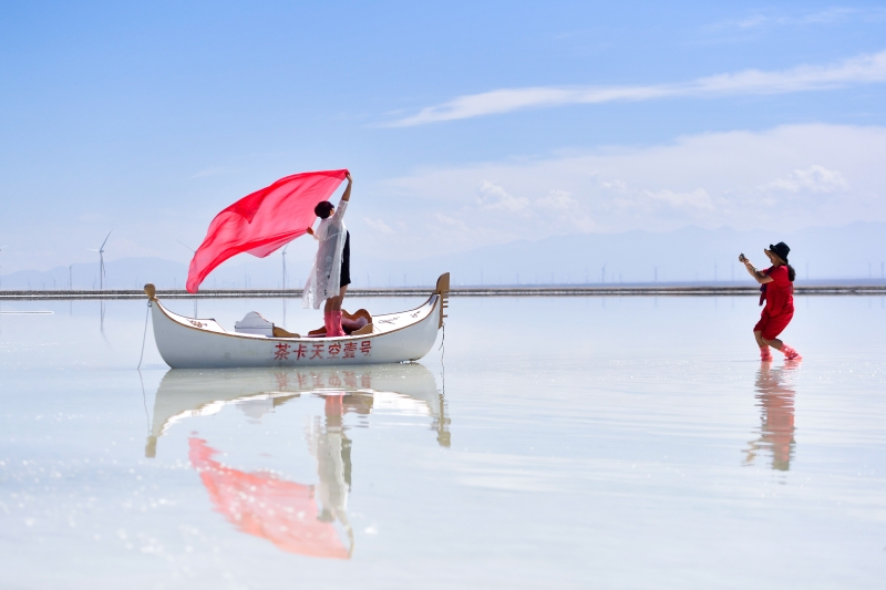 游客在青海省乌兰县茶卡盐湖“天空壹号”景区拍照，彷佛进入了盐海蓝天的梦幻空间。
