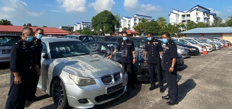 沙鲁阿兹哈（右三）与陆交局官员展示被拍卖的各类轿车。