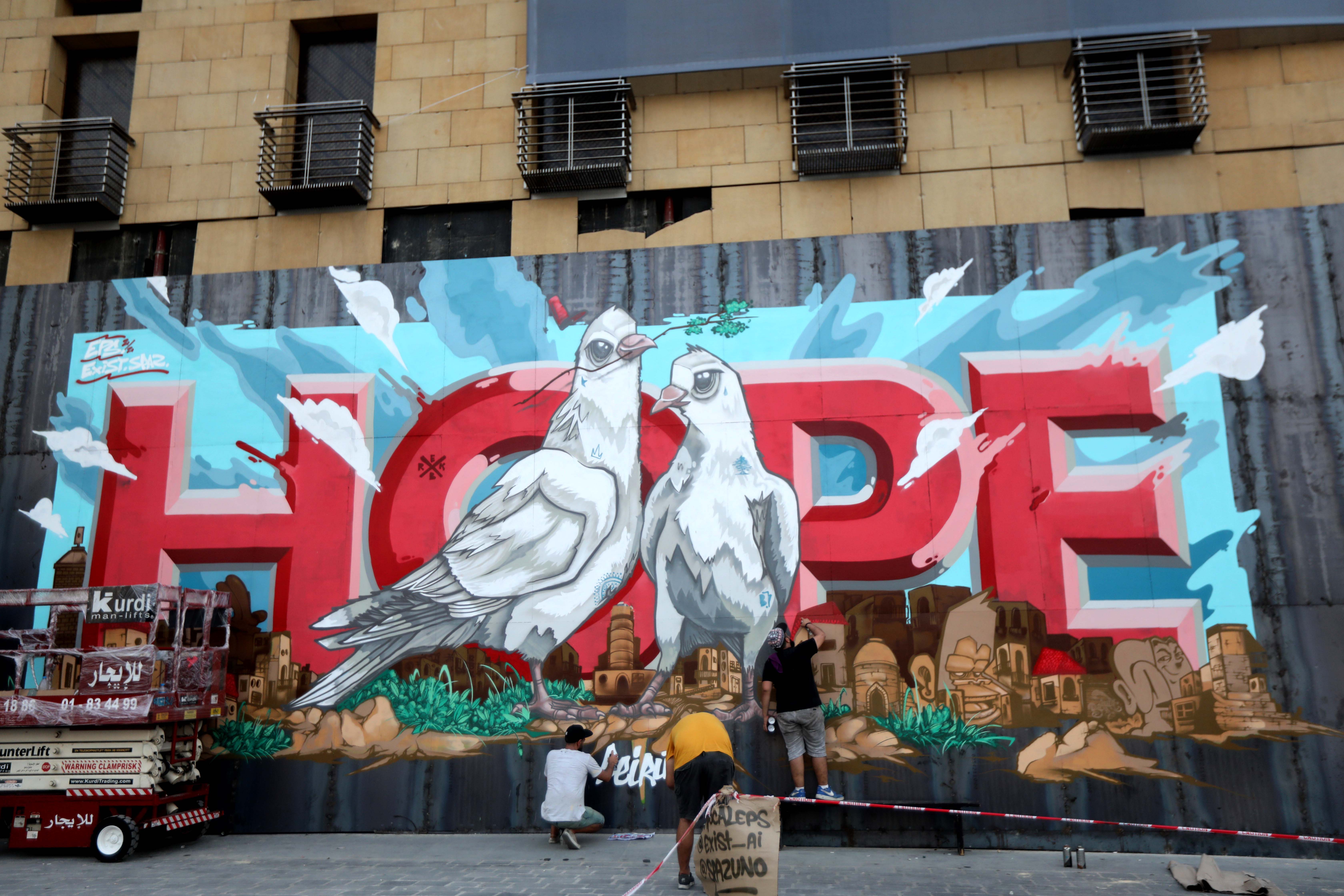 一群壁画家在墙上创作以“希望”为主题的壁画，借此激励所有黎巴嫩人乐观面对未来。（图：新华社）