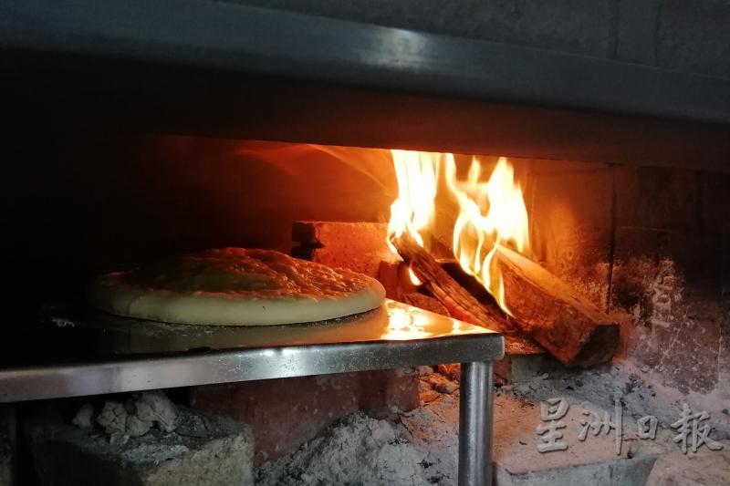 披萨在窑炉里受热，饼皮开始膨胀。