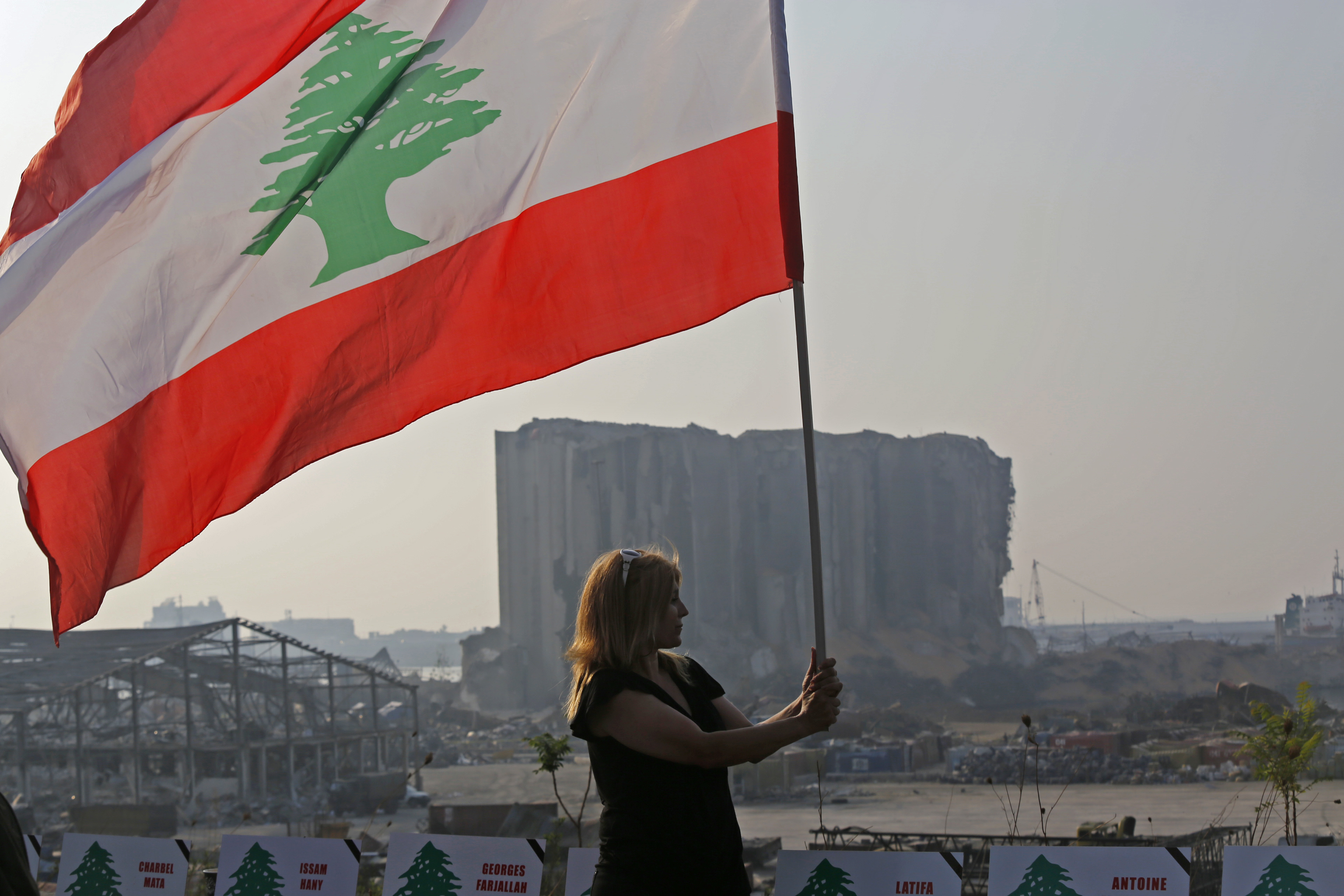 在悼念活动上，一名女士手持黎巴嫩国旗，展现爱国情操。（图：新华社）