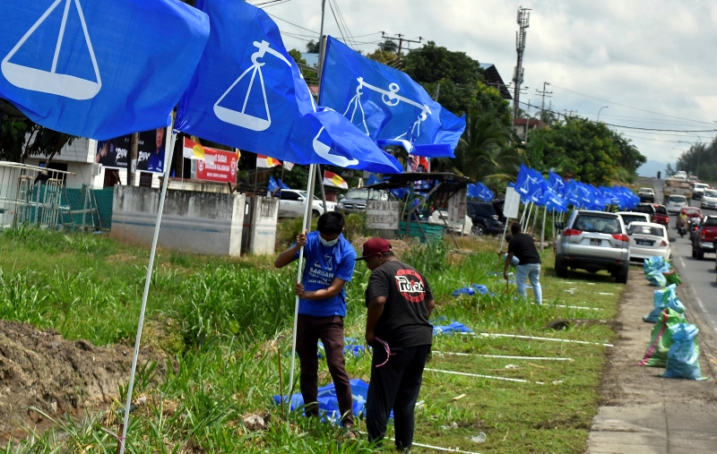 国阵助选人员开始员在路旁插上国阵旗帜。