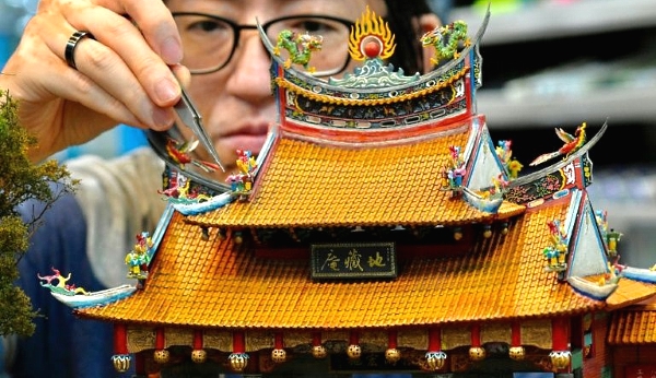 Chen Shih-jen works on a model of a temple. AFP