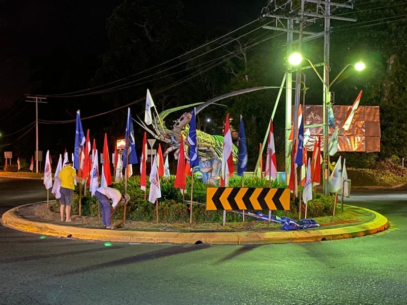 工作人员在石咀交通岛插上国阵党旗。
