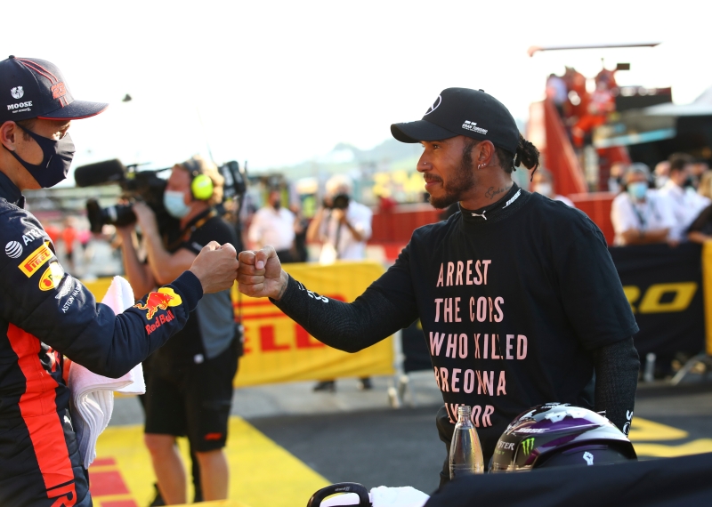 在多次错失良机后，阿尔本（左）终于在F1托斯卡纳站生涯首度登上颁奖台，为F1赛史泰籍车手第1人。图为阿尔本在赛后与汉密尔顿（右）击拳互贺。（美联社照片）