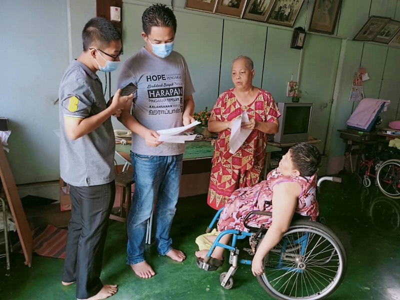 张聒翔（左二）到陈加陆的家中，亲自了解她需要轮椅的问题。