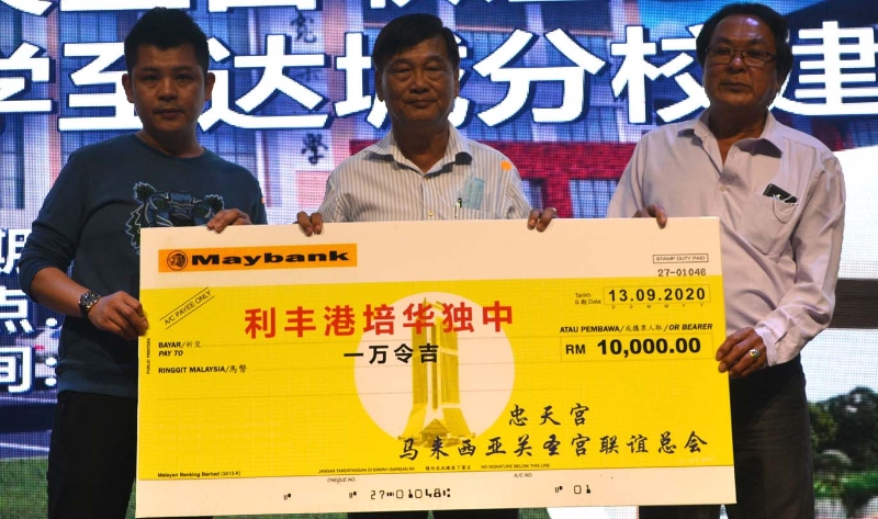 刘凌丰（左）、吴铁坤（右）移交捐献给培华独中署理董事长郑亚玖。
