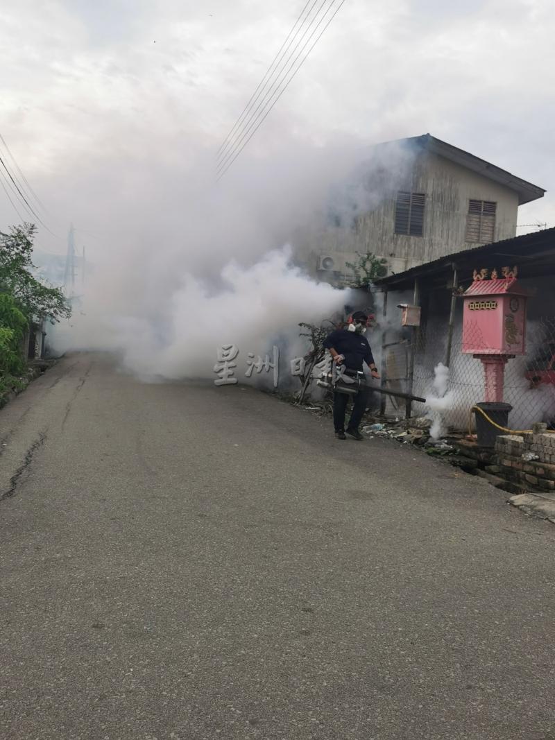 卫生局官员在新村喷射蚊雾，杜绝黑斑蚊滋生。