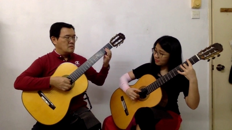 同是校友的父女档李国邦（左）及李悦双（右）表演吉他二重奏。