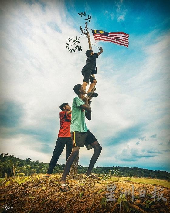 陈建羽以3族人民“互撑”高挂国旗的照片拿下摄影组冠军。