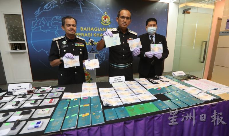 凯鲁（中）展示起获的印尼护照和伪制盖章。左为副总监法兹和右为情报、特别行动和分析组主任巴斯里。
