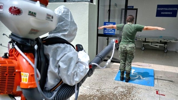 Erika Ramirez disinfects a colleague at a military hospital where she says she goes about her work with no fear. AFP