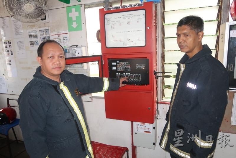 依梅尔（左）讲解火灾警报器的操作，右为玛祖基。