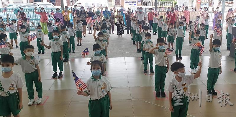 怡保中山幼儿园的小朋友扬起小国旗欢庆马来西亚日。后前排左起是陈绣云、黄喜明；后前排右一起冯伟权、温炳楠、苏美玉。