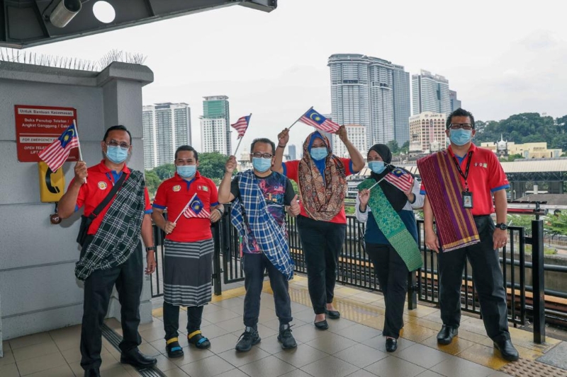 莫哈末尼占（左三）与国家基建公司员工披上纱笼，欢庆马来西亚日。