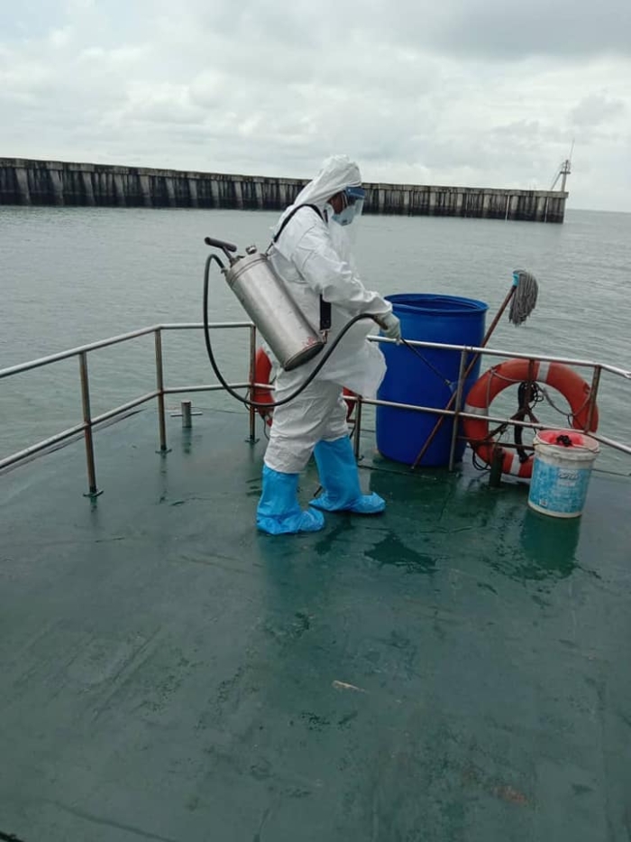 卫生局人员在船只上进行消毒工作。