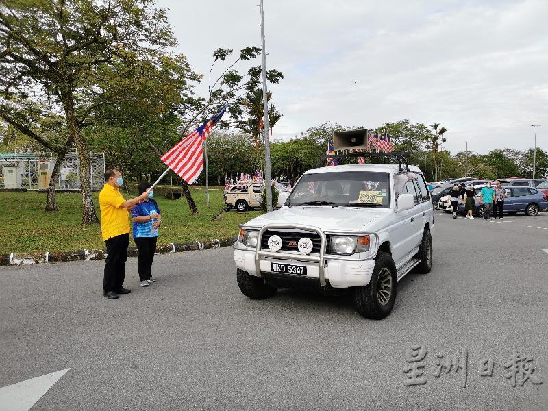 人联党民都鲁支部主席潘隆铭（左）为916马来西亚日车队游行主持挥旗仪式。