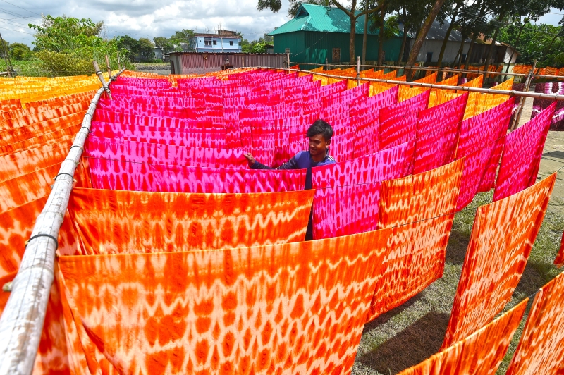村民将手工印染后的布匹进行晾晒，呈现不一样的景色。（图：新华社）