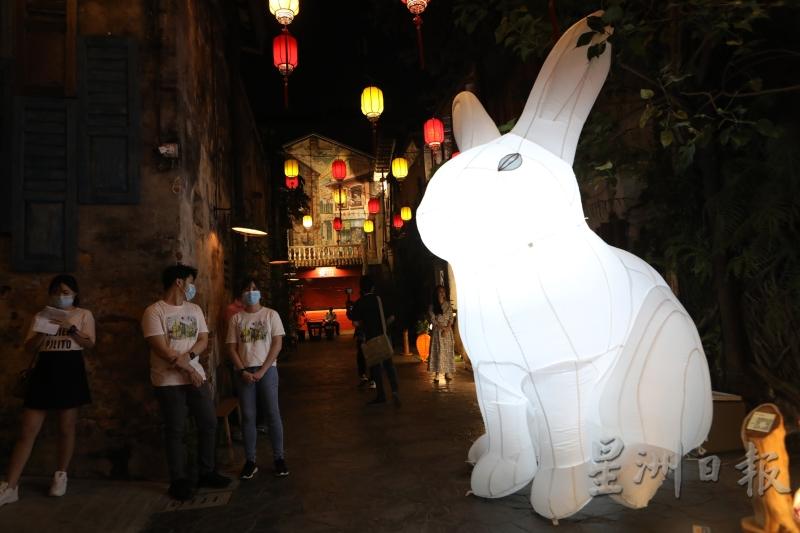 鬼仔巷正中央摆放显眼的纯白巨兔造型充气模，吸引许多人拍照。
