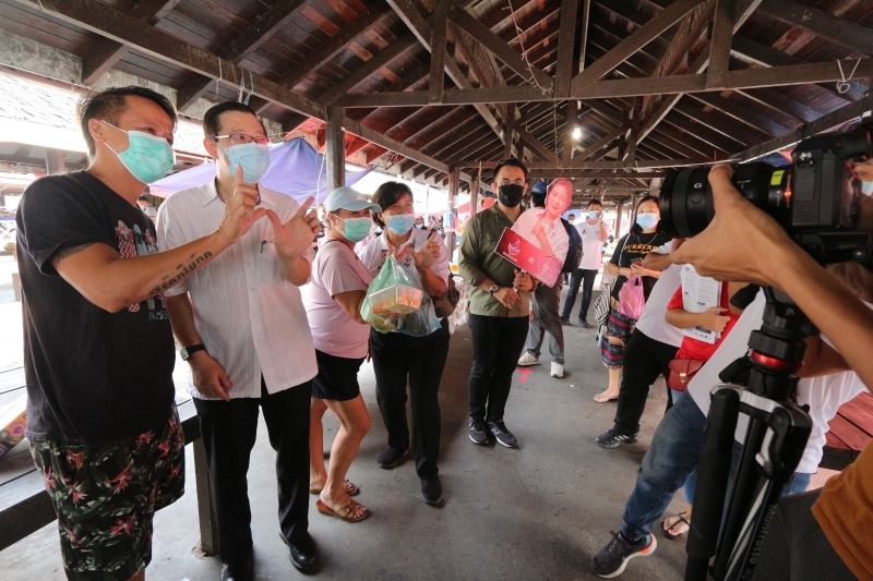 林冠英（左二）、珍妮（左四）及大山脚国会议员沈志强（左五）在东贡岸斗磨拜票时，与民众一同比出泛民兴党的手势。