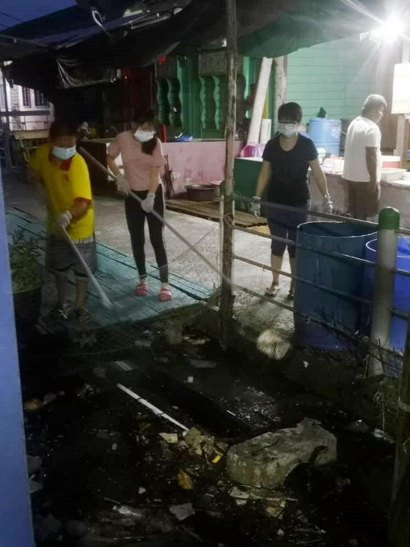 五条港居民一家大小在天未亮就分工合作捞垃圾，为渔村的整洁献力。