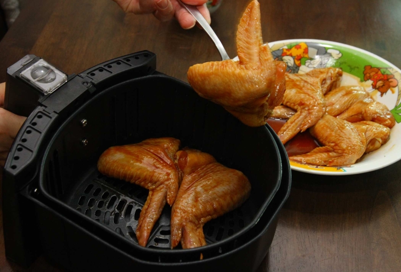 将腌制好的鸡翅，放入气炸锅，多余的酱汁可以涂抹在鸡翅上。