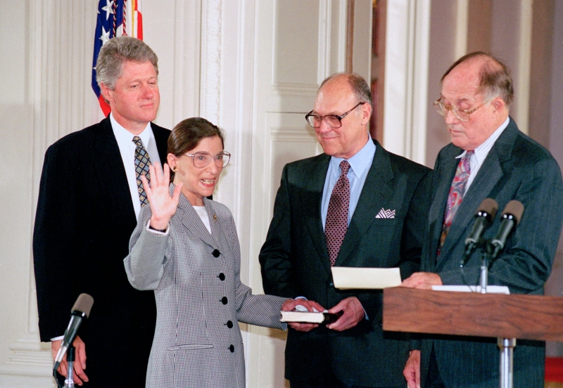 金斯伯格于1993年宣誓就任最高法院大法官，是美国历史上第二位女性大法官。其身后为任命她的时任美国总统克林顿。