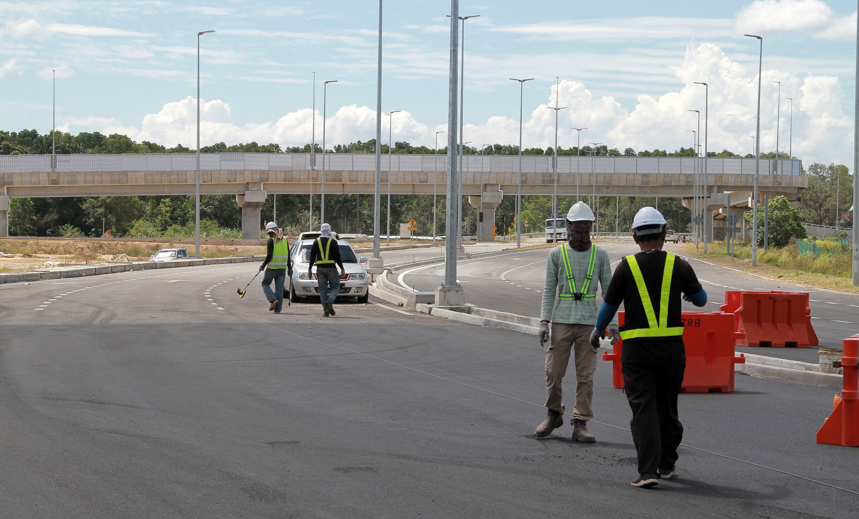 承包商员工在丹绒弄坡第二大桥路口处画上道路路线。