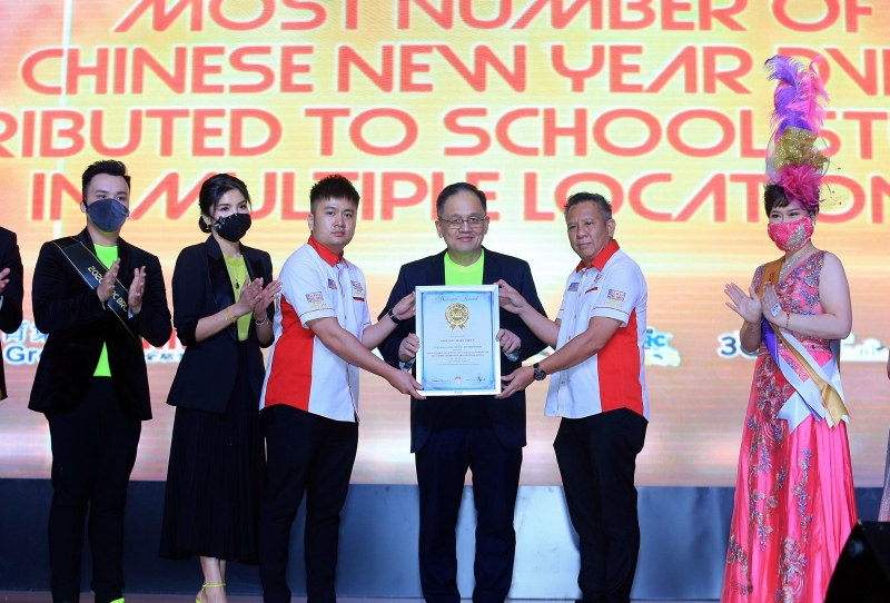 林得丁博士（右三）从杨重振（右二）、黄程运（右四）手中领取“马来西亚颁发最多新年专辑给学生”大马纪录大全荣誉奖状。