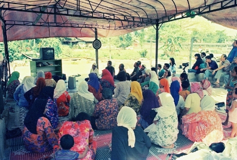 甘榜朱芭达村民聚集观赏纪录片，了解自己的权益。