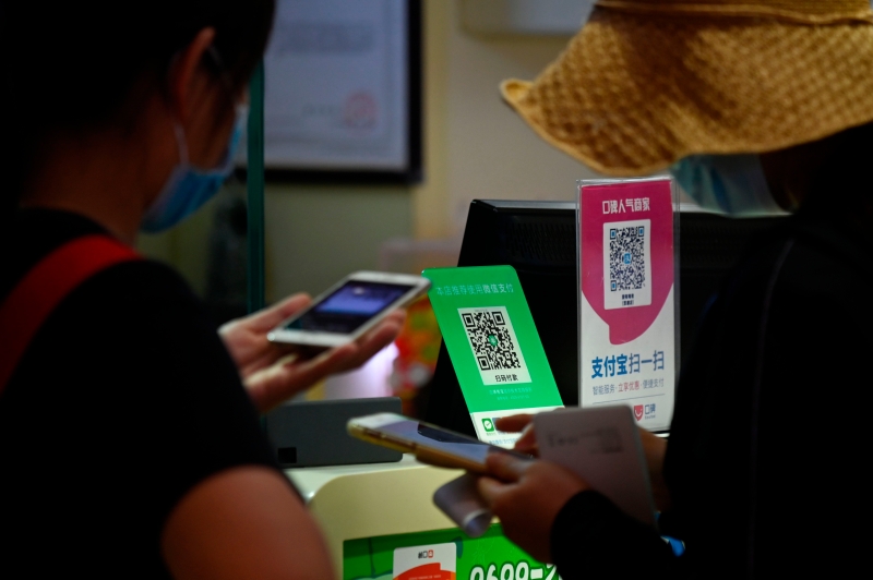 图为在北京一家食品店，民众利用微信（左）和支付宝的电子钱包付账。（法新社照片）