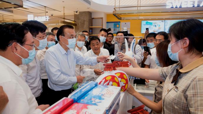 李克强在上海考察期间，在泰康食品店付钱买了两包大白兔奶糖。不过有网友质疑李克强为何不使用移动支付，而选择付现金。（互联网照片）