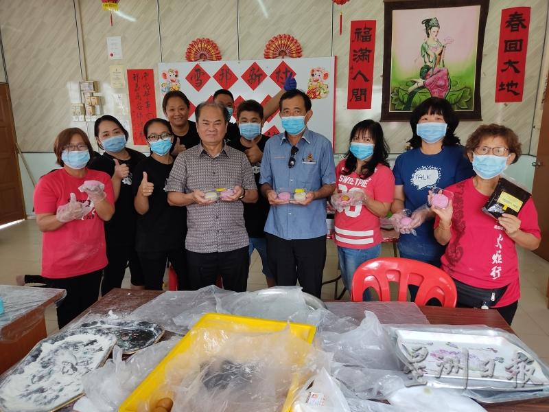 刘天球（前排左二）和雪邦村长戴祖兴（前排左三）等人展示义工们制作的爱心月饼。