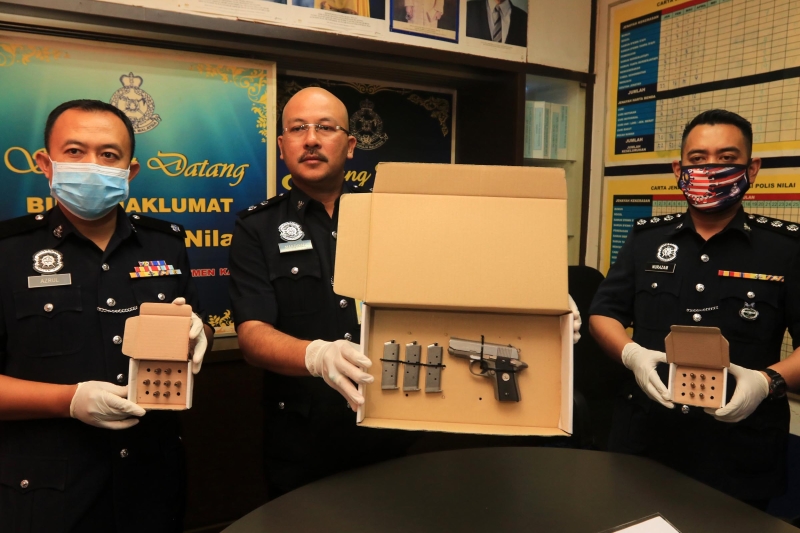 诺玛祖基（中）、汝来警区副主任阿兹鲁（左）及刑事罪案调查组主任努拉赞（右）展示起获的手枪、子弹和弹匣。