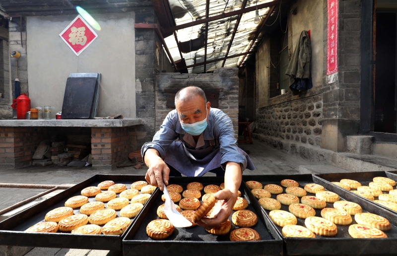 “端盛长”传统手工月饼制作工坊的工作人员在检查烘烤好的月饼。