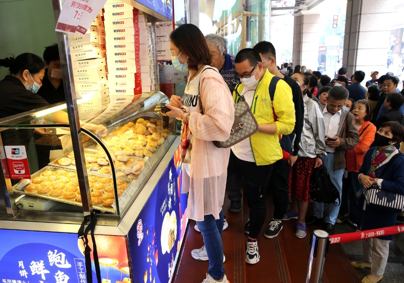 顾客在上海南京路上排队购买现场制作的散装鲜肉月饼。   
