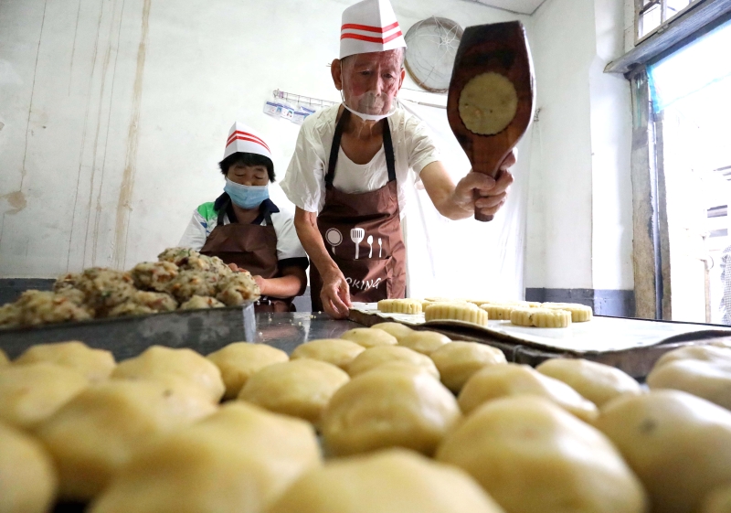 中国河北省石家庄市井陉县天长镇的“端盛长”传统手工月饼制作工坊的经营者、72岁的于银柱用手工刻制的模具制作月饼。  