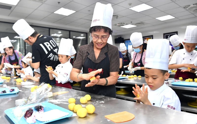临近中秋，中国西安百余名家长和小朋友走进当地的烘焙工厂体验月饼制作，迎接中秋佳节。   