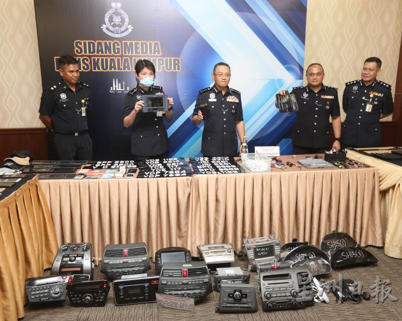 赛夫（中）在吉隆坡副总警长拿督杨丽珠（左二）及其他警官陪同下，向媒体展示警方起获的轿车零件。