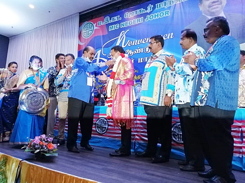 国大党柔州主席阿威雅（右五）为开幕人沙拉瓦南（右四）套上花环及披上围巾。