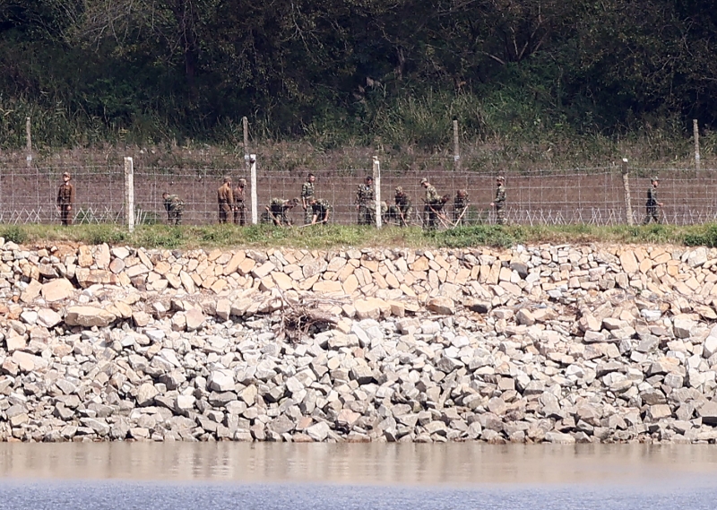 从韩国江华岛的非军事区眺望，周五可见到一些朝鲜士兵出现在边境堤防旁。（法新社照片）