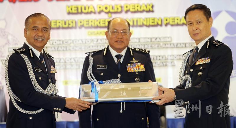 吴文恭（右）于9月7日从纳沙鲁丁手中接过职权，出任霹雳州代总警长，中为全国社区安全与防范罪案组总监拿督再纳阿比丁见证。