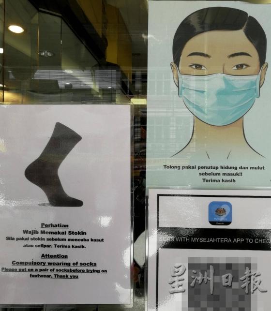 有关商家在店门有张贴告示图，提醒顾客须穿上袜子才可试鞋。