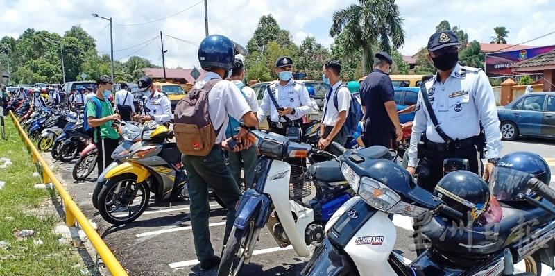 交警对放学后取摩托车的学生，展开逐个检查。