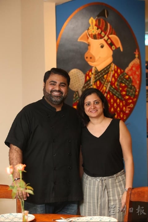 夫妻档老板Herukh 与Aahana，Herukh兼任主厨，Aahana负责餐厅装潢，背景那幅可爱的猪头王公画作正是Aahana的作品。