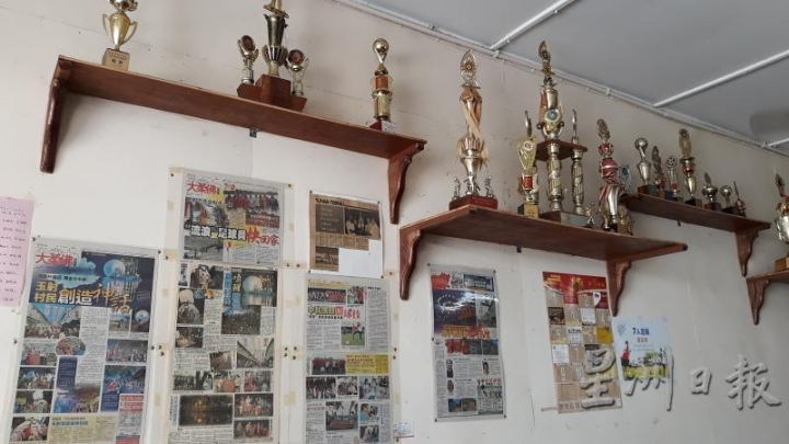 Buji咖啡店里的一座座奖杯与墙上的一张张玉射剪报互相辉映。